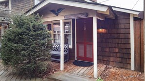 A wooden cottage with a porch, a sign reading "Perfect Moment Cottage," and a small tree in front. - Perfect Moment Cottage (Blowing Rock)