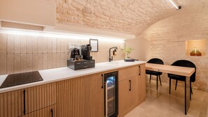 A modern kitchen with a built-in oven, a coffee machine, and a sink.