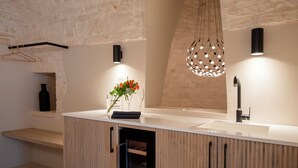 A modern bathroom with a wooden vanity, a large mirror, and a hanging light fixture.