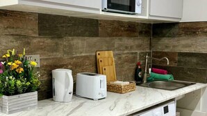 Une cuisine équipée d’un four à micro-ondes, d’un grille-pain et d’un évier.