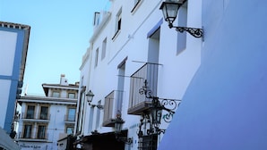 A narrow street with white buildings, balconies, and a sign for "La Posada del Mar". - Elegante Apartamento Frente al Puerto de Denia (Dénia)