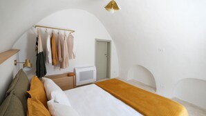 A bedroom with a bed, a bedside table, a lamp, a wardrobe, and a door. - House in the historic center with terrace and panoramic view of the Itria Valley (Locorotondo)