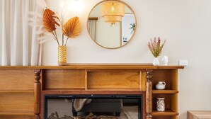 A wooden fireplace with a glass front, a mirror above it, and a shelf with decorative items. - Harbourview House - coast chic in the CBD (ALBANY)