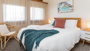 A hotel room with a bed, a chair, a nightstand, and a painting on the wall. - Harbourview House - coast chic in the CBD (ALBANY)