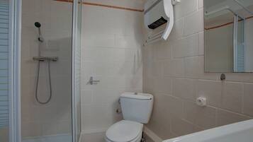 A bathroom with a shower, toilet, and bathtub.