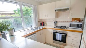 A modern kitchen with a gas stove, oven, microwave, and a sink. - This snug 3 bedroom villa is all you need to call home whilst visiting Albany (MIDDLETON BEACH)