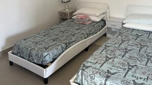 A bedroom with a single bed, a nightstand, a lamp, and a wall-mounted TV. - Studio mini (Centonara)