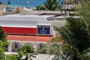 A building with a red-tiled roof and a sign for a money exchange. - Heart designed Apartment, Ocean and Lagoon view, large terrace  (Cancún)