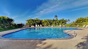 A swimming pool with lounge chairs and palm trees. - Wailea Ekolu Village 1406 by Maui Rental Group (Kihei)