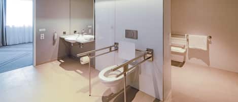 A modern bathroom with a toilet, sink, and mirror.