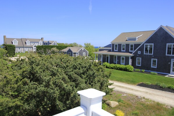 A residential area with multiple houses, a well-maintained lawn, and a clear sky. - 99 Wing Blvd W (Sandwich)