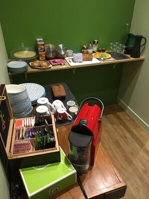 Uma área de cozinha com cafeteira, chaleira e diversos utensílios.
