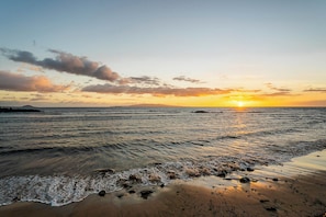 Ein Strand mit Wellen bei Sonnenuntergang.