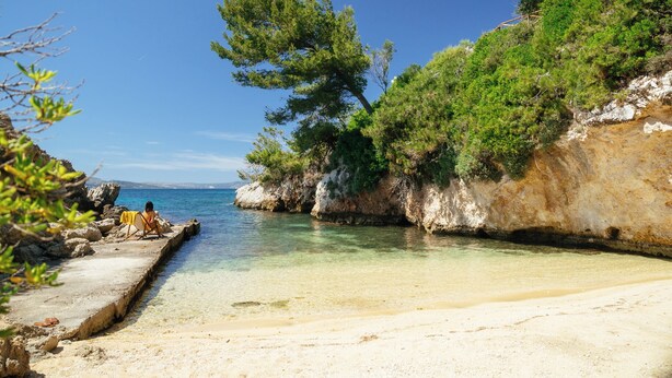 A beach with clear water, rocky cliffs, and greenery. - Via Lassi bungalow 6 (Ioanian Islands)
