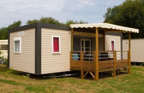 Une maison mobile dotée d’un porche abrité et d’une petite fenêtre.