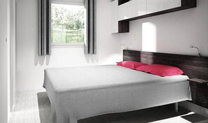 Une chambre à coucher moderne avec un lit, une table de chevet et une fenêtre avec des rideaux.