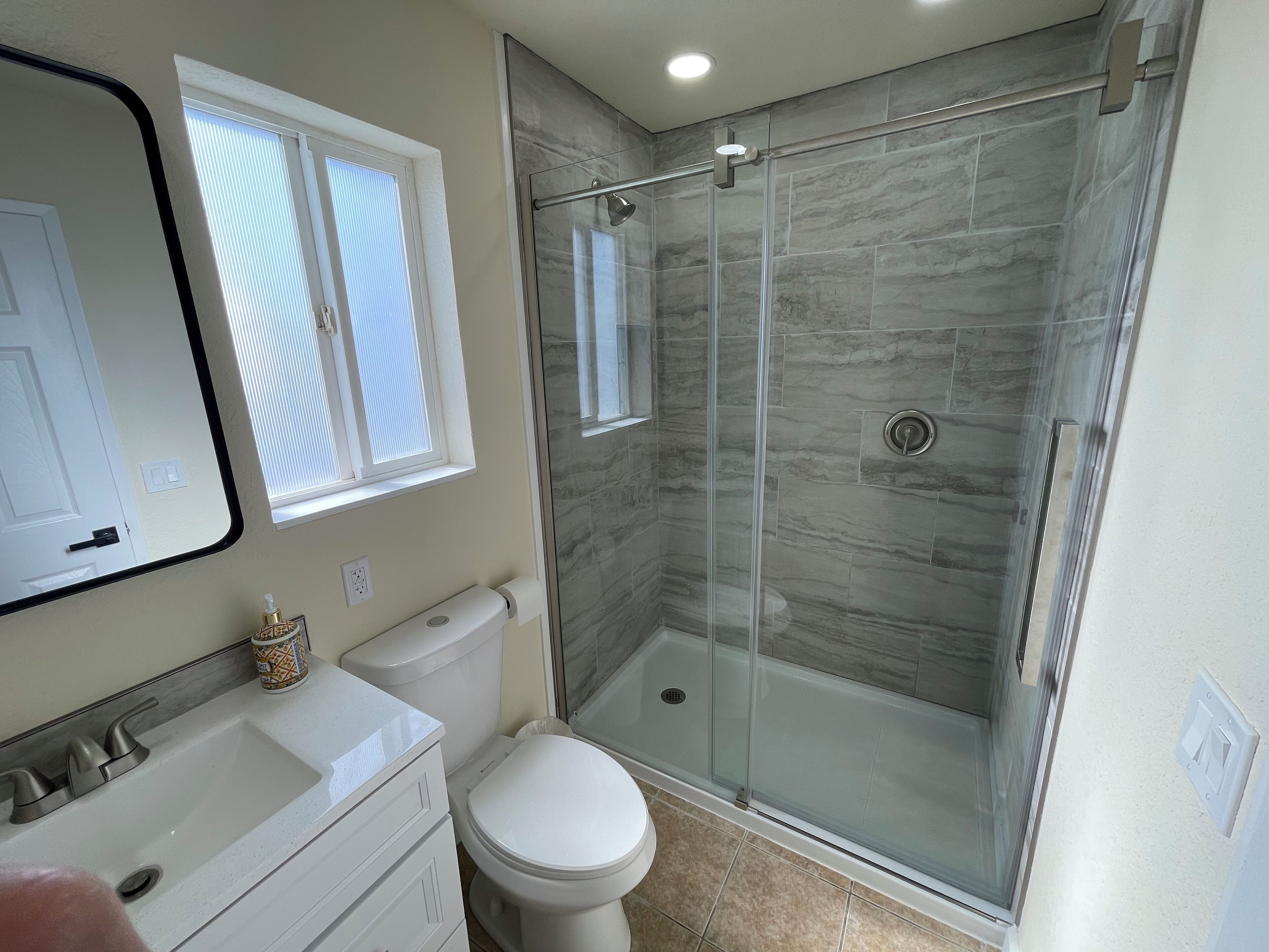 Une salle de bain avec des toilettes, un lavabo et une douche.