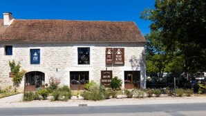 Un bâtiment en pierre avec des enseignes indiquant « Chez Village », « Sophie du Port » et « Camping ».