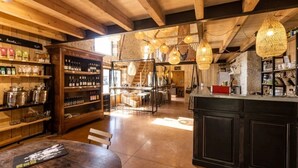 Un intérieur rustique avec des poutres en bois, un coin bar et des luminaires suspendus.