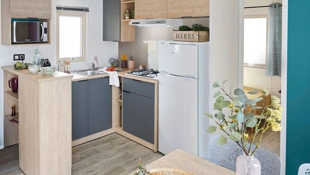 A compact kitchen with a central island, a microwave, a gas stove, and a refrigerator.