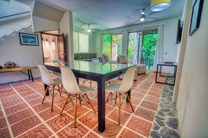 Comedor con mesa de vidrio, cuatro sillas y piso con diseño.
