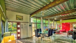 A spacious room with a stone floor, a glass table, and modern furniture. - Arroyos Verdes (Bucerías)