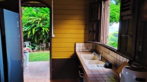 A compact kitchen with a sink, a window, and a door leading to a small outdoor area. - 3 Bedroom Villa in Le Robert (Le Robert)