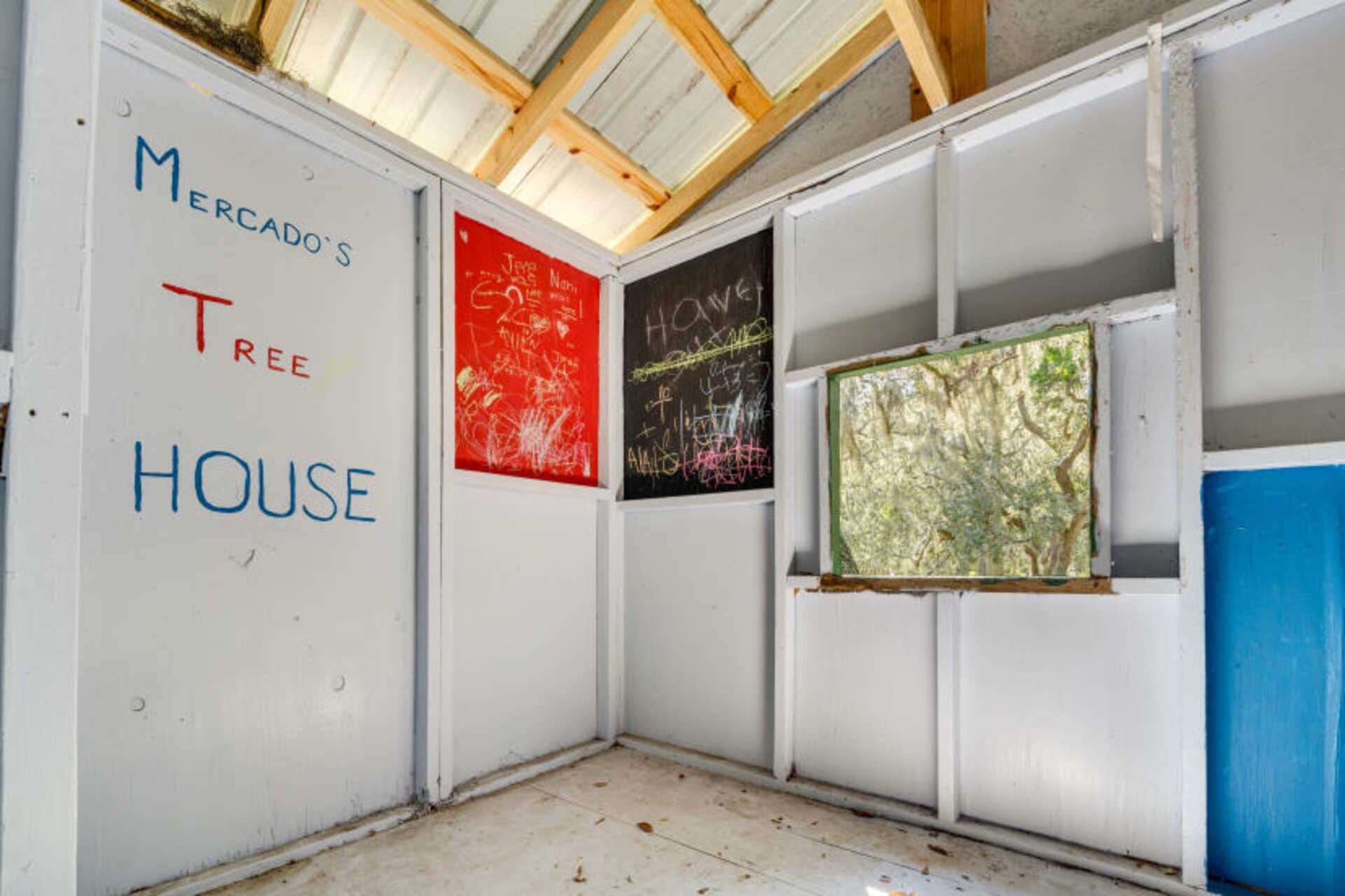 A room with a white wall displaying 'Mercado's Tree House'.