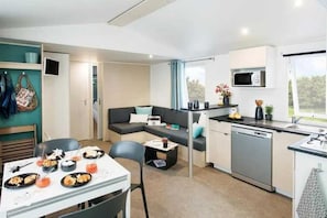 A compact living space with a kitchenette, dining area, and a sofa.
