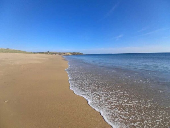 A beach with a clear sky and calm sea.
