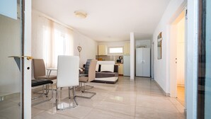 A modern apartment with a dining area, a sofa, a kitchen, and a living room. - Bbq Holly Garden Novalja D (Novalja)