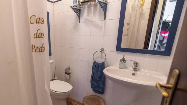 Ein Badezimmer mit Toilette, Waschbecken, Spiegel und einem Handtuch an der Wand.