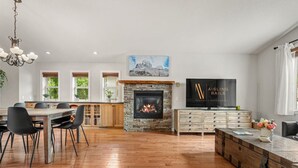 A spacious living room with a fireplace, dining area, and a television.