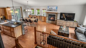 A spacious living area with a fireplace, a dining table, and a kitchen with wooden cabinets.