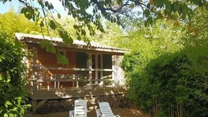 A wooden cabin with a porch and two white lounge chairs in front. - ZEcamping 3 étoiles pataugeoire pet friendly animations chalet 22m2 5 pers (Darbres)