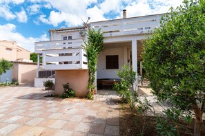 A modern two-story house with a covered patio, a small garden, and a paved driveway. - Apartments Valy 5 Center Novalja (Novalja)
