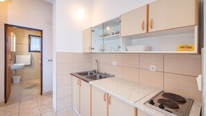 Een moderne keuken met een spoelbak, fornuis en open kastjes.