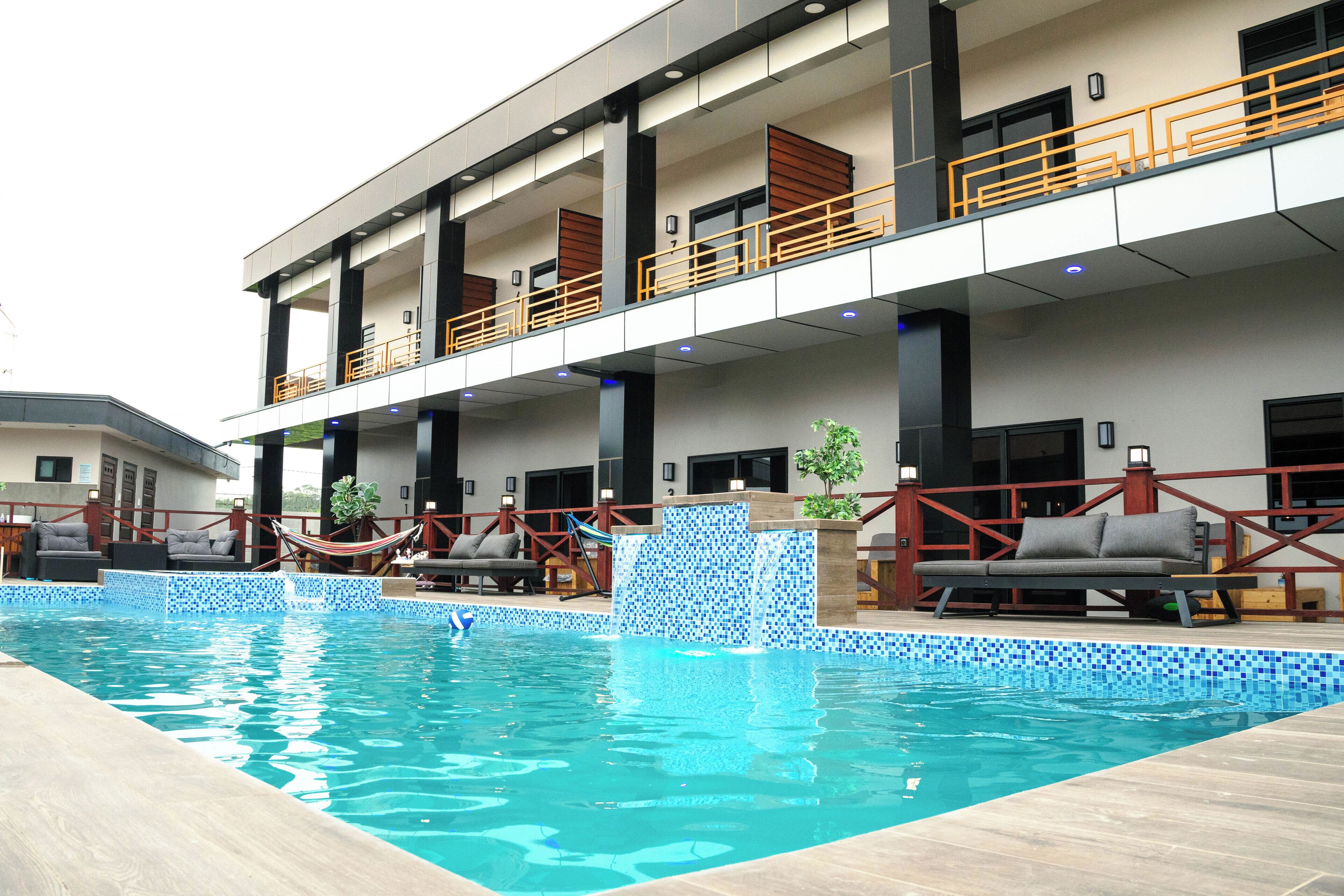 Ett modernt hotell med en swimmingpool, utomhusplats och en täckt terrass.