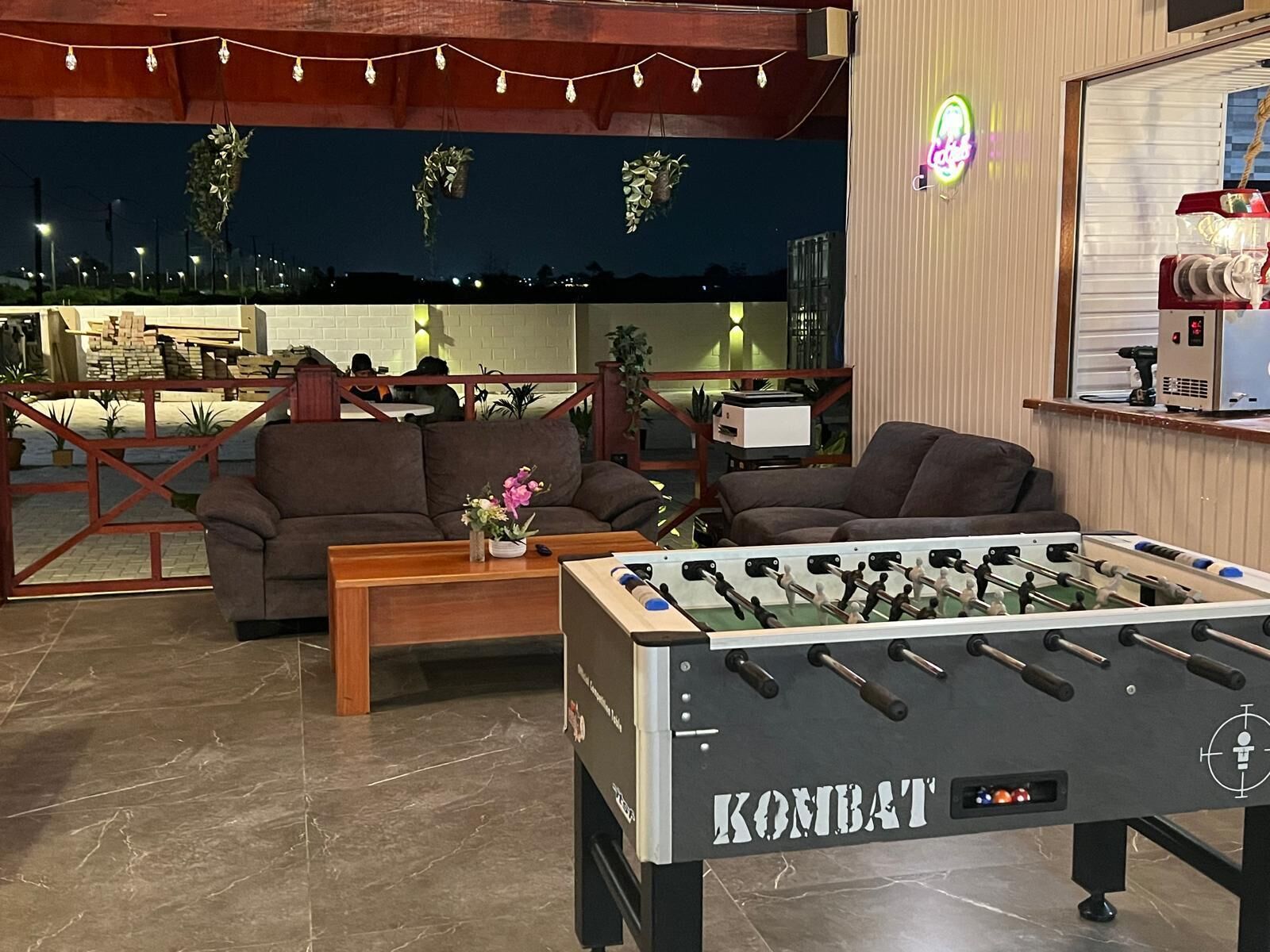 Ein gemütliches Interieur mit einem Kicker, der 'KONBAT' genannt ist, und zwei Sofas.