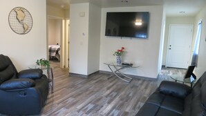 A living room with a flat-screen TV, a glass coffee table, and two leather sofas. - 4 Bdr/2 Bath-Interior Alaska-Moose Creek , North Pole. Minutes from Eielson AFB (North Pole)