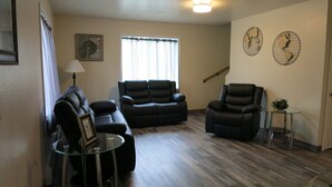 A living room with a sofa set, two recliners, a glass coffee table, and a small side table with a plant. - 4 Bdr/2 Bath-Interior Alaska-Moose Creek , North Pole. Minutes from Eielson AFB (North Pole)