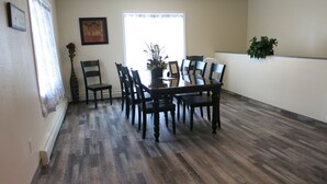 A dining area with a wooden table and chairs, a vase with flowers, and a framed picture on the wall. - 4 Bdr/2 Bath-Interior Alaska-Moose Creek , North Pole. Minutes from Eielson AFB (North Pole)
