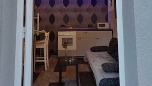 A compact living space with a kitchenette, a dining area, and a sofa.