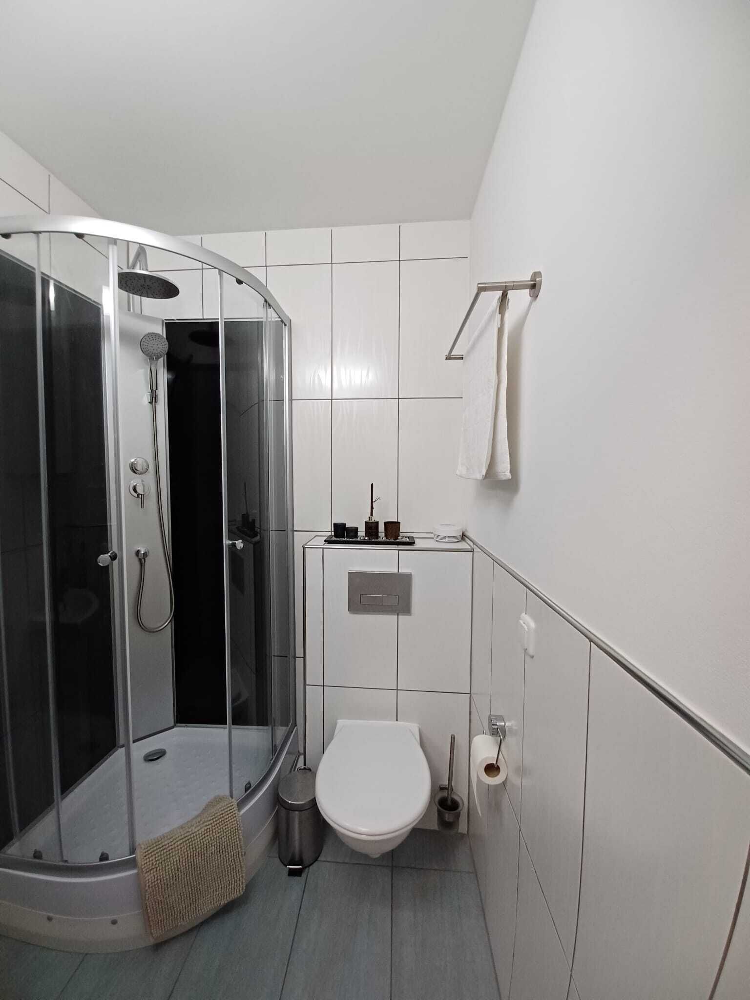 Un baño moderno con ducha de vidrio, inodoro y lavabo.