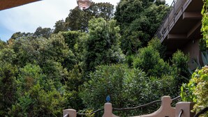 A set of outdoor stairs leading up to a building, surrounded by lush greenery and a metal railing. - HOUSE & PRIVATE SWIMMING POOL SEA VIEW very quiet (Porto-Vecchio)