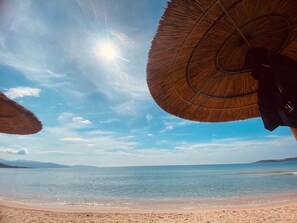Une scène de plage avec un ciel dégagé et une mer calme.