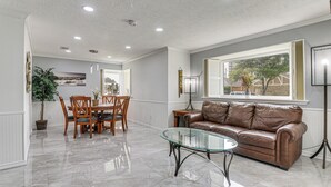 A spacious living area with a dining table, leather sofa, and a glass coffee table. - ~ 2 Blocks to Beach: Galveston Group Getaway! (Galveston)