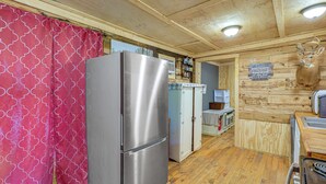 Un intérieur en bois comprenant un réfrigérateur, un four à micro-ondes et un évier.