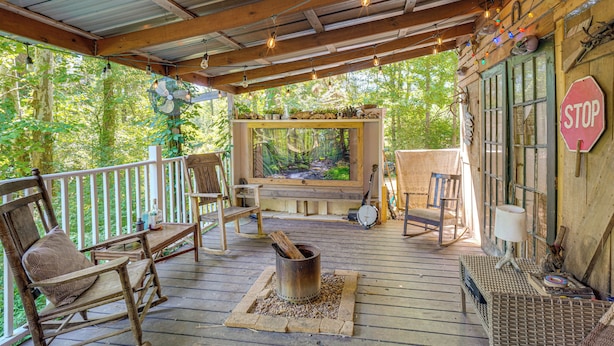 Une terrasse en bois avec un foyer, des sièges, un téléviseur et un panneau de signalisation indiquant un arrêt.