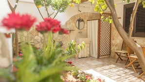 Un bagno con pareti in pietra, un lavandino, uno specchio e una tenda da doccia.